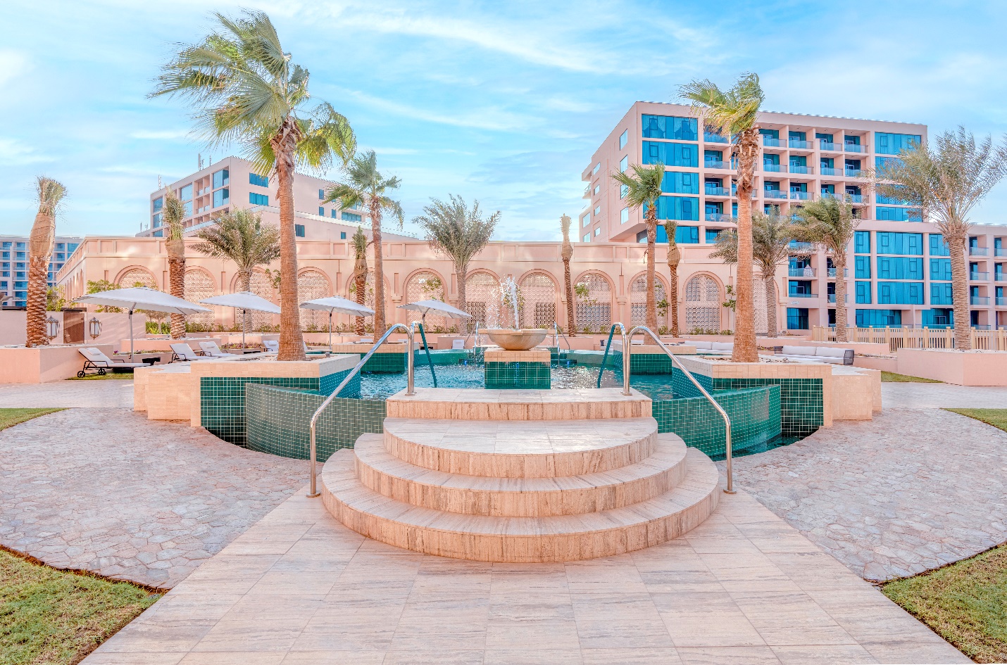 A pool with steps and palm trees

Description automatically generated
